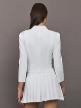 Model wears white jacket with a front zipper, collared neck and long sleeves.
