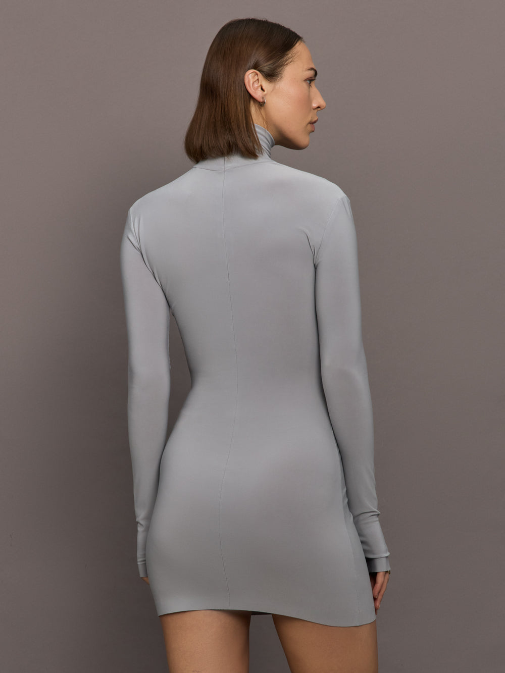Model is wearing Long Sleeve Turtleneck Mini Dress in Grey, back view highlighting seamless finish and slim profile.