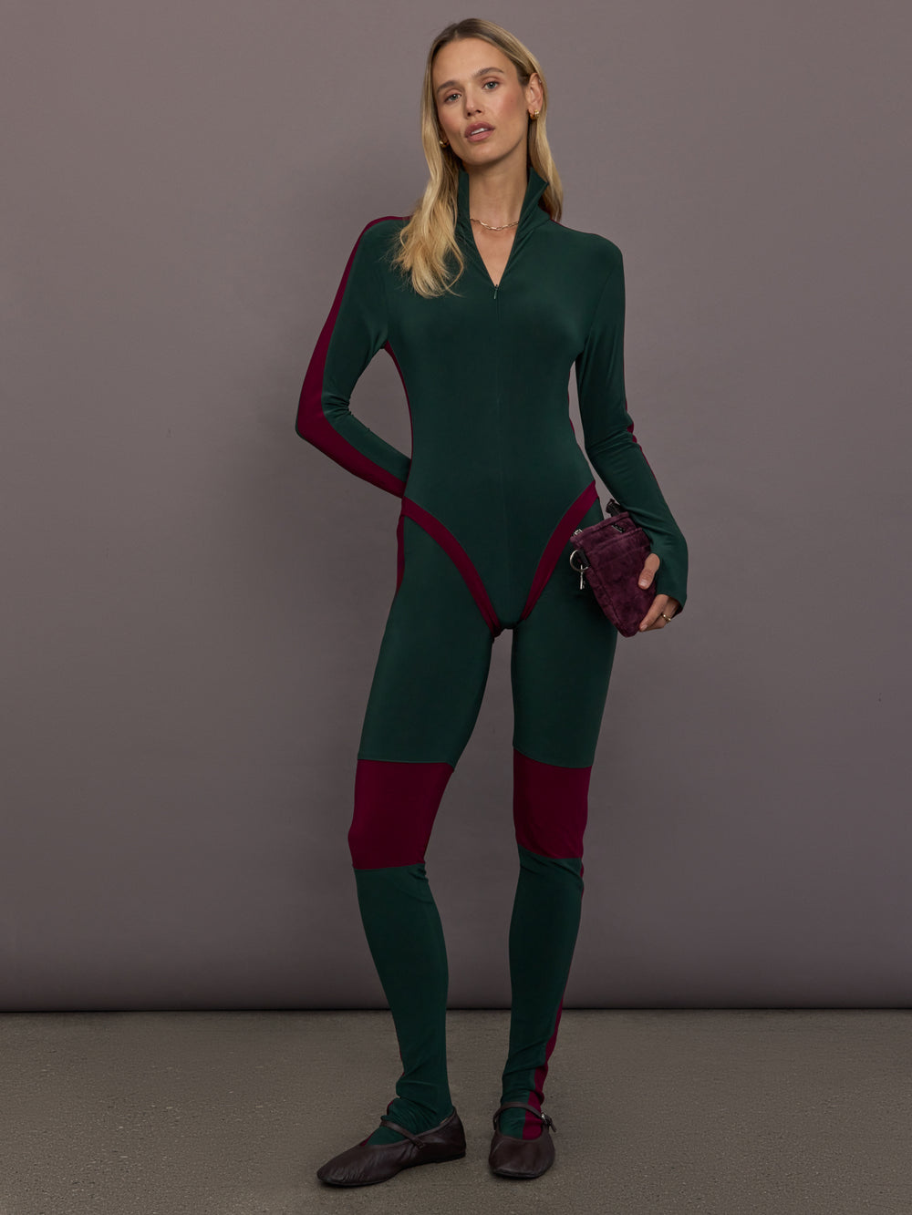 Model is wearing Side Stripe Legging With Knee Patch in Dark Emerald and Plum, full body front view styled with matching bodysuit.