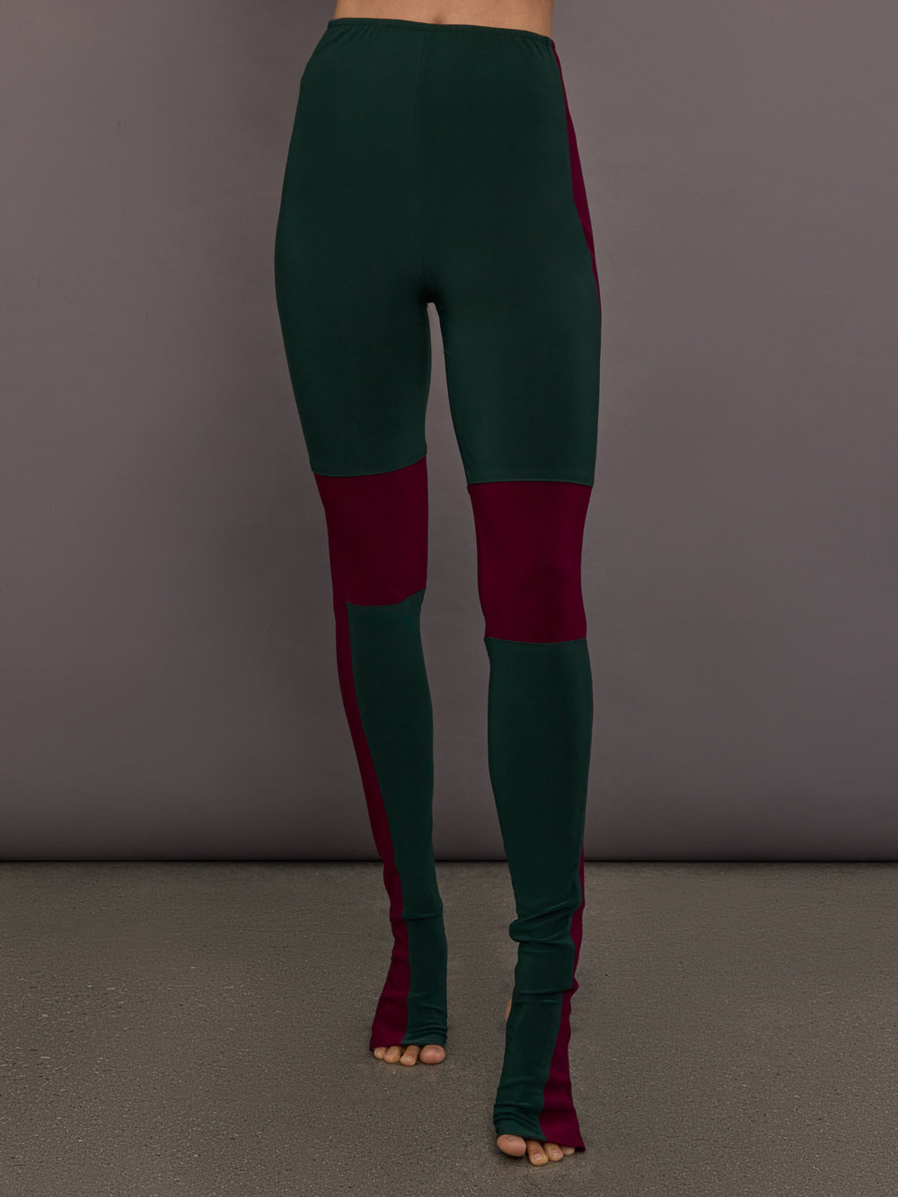 Model is wearing Side Stripe Legging With Knee Patch in Dark Emerald and Plum, front view showing knee patch placement.