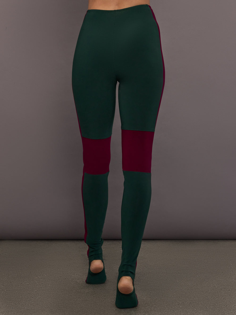 Model is wearing Side Stripe Legging With Knee Patch in Dark Emerald and Plum, back view showing full length fit.