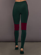 Model is wearing Side Stripe Legging With Knee Patch in Dark Emerald and Plum, back view showing full length fit.