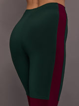 Model is wearing Side Stripe Legging With Knee Patch in Dark Emerald and Plum, close-up of side stripe and hip panel.