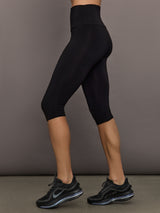 Model is wearing Pedal Pusher in Black, side profile fit view.