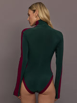 Model is wearing Side Stripe Zip Front Long Sleeve Turtleneck Bodysuit in Dark Emerald and Plum, back view with full coverage fit.