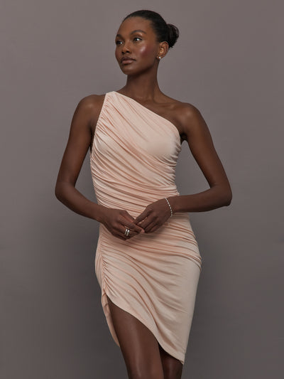 Model wears the Diana Mini Dress in Baby Pink, featuring a sleeveless, asymmetrical design with a fitted bodice