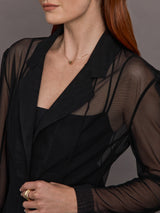 Model wears black single-breasted mesh jacket with a collared neck and tailored fit.
