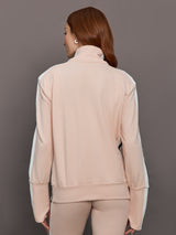 Model wears baby pink jacket with a turtleneck, front zipper, and side stripes on the sleeves.
