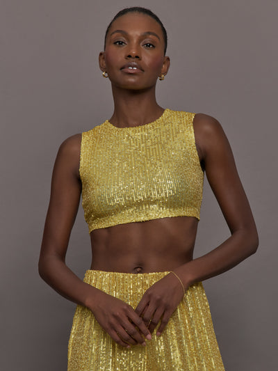 Model wears the Sleeveless Slim Fit Cropped Top in Asparagus, featuring a fitted, cropped, high neck design with sparkles.