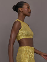 Model wears the Sleeveless Slim Fit Cropped Top in Asparagus, featuring a fitted, cropped, high neck design with sparkles.