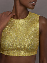 Model wears the Sleeveless Slim Fit Cropped Top in Asparagus, featuring a fitted, cropped, high neck design with sparkles.