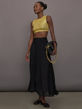 Model wears the Sleeveless Slim Fit Cropped Top in Asparagus, featuring a fitted, cropped, high neck design with sparkles.
