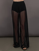 Model wears black high-waisted mesh pants with a wide leg fit.


