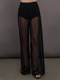 Model wears black high-waisted mesh pants with a wide leg fit.


