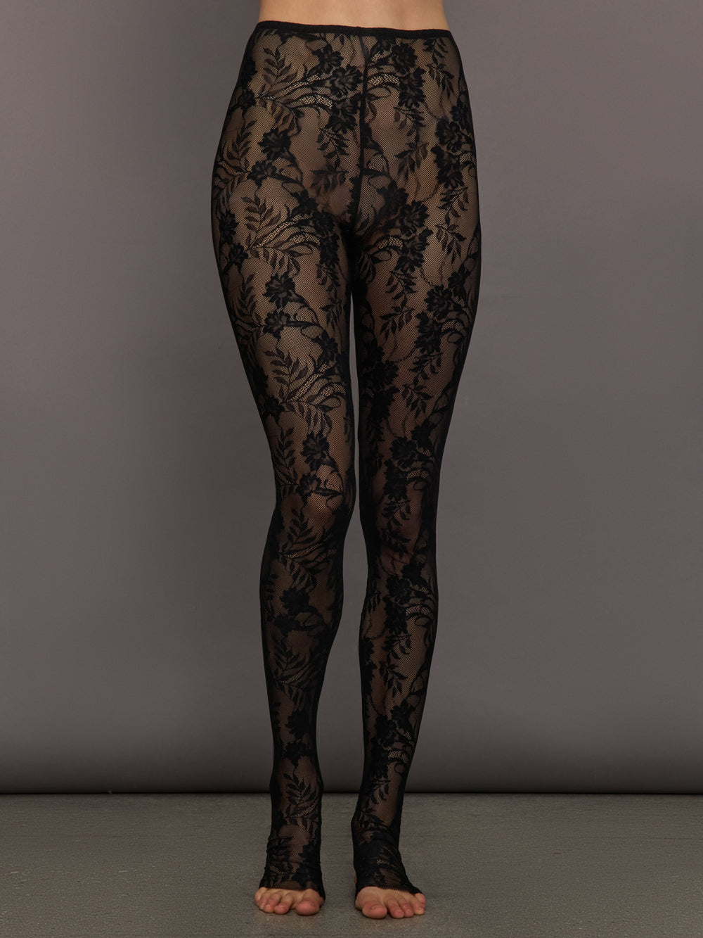 Black floral lace tights on a gray background