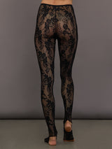 Black lace leggings worn by a person on a gray background