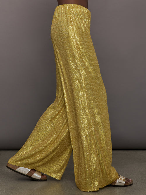 Model wears the Boyfriend Elephant Sweatpants in Asparagus, featuring a relaxed, tapered fit with oversized legs and sparkles.