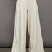 Model wears a pair of oversized wide leg cream colored sweatpants. 