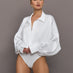 Model wears a white long sleeved bodysuit with oversized cuffed sleeves and a collar. 