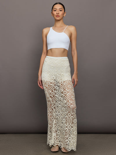 Model wears the Obie Long Skirt in cream, with a high waist, flower detailing and flared bottom.