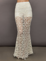 Model wears the Obie Long Skirt in cream, with a high waist, flower detailing and flared bottom.