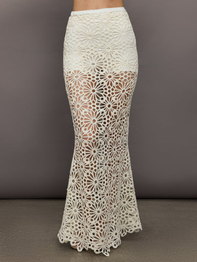 Model wears the Obie Long Skirt in cream, with a high waist, flower detailing and flared bottom.