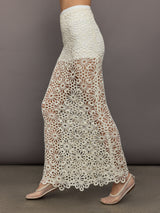 Model wears the Obie Long Skirt in cream, with a high waist, flower detailing and flared bottom.