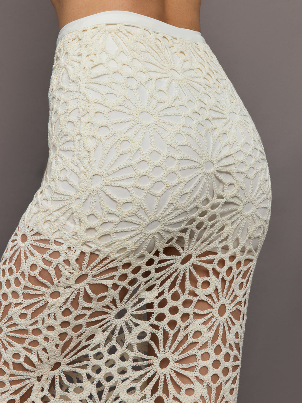 Model wears the Obie Long Skirt in cream, with a high waist, flower detailing and flared bottom.