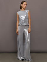 Model is wearing sleeveless twist top in silver, full body view.