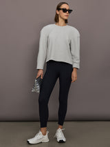 Model is wearing Bomber 1980s Sweatshirt in Light Heather Grey, full body styling.
