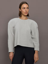 Model is wearing Bomber 1980s Sweatshirt in Light Heather Grey, front view.