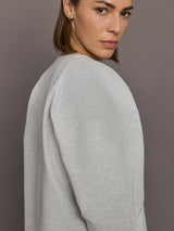 Model is wearing Bomber 1980s Sweatshirt in Light Heather Grey, shoulder and fabric close-up.