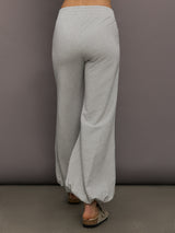 Model is wearing Boyfriend Puff Jog Pant in Light Heather Grey, back view.