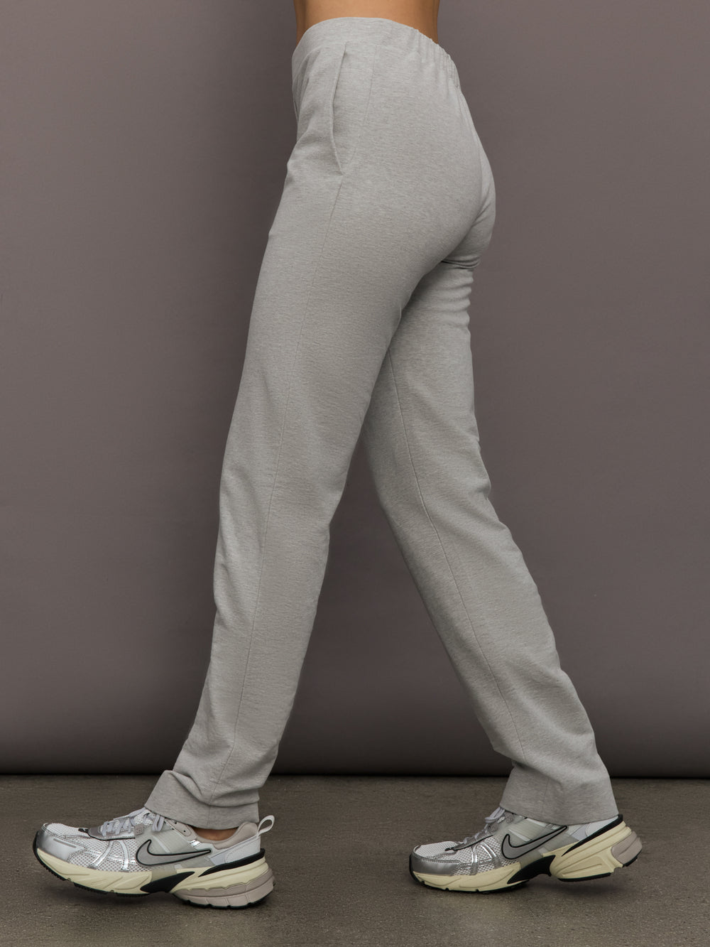Model is wearing Flat Front Mens Pant in Light Heather Grey, side view.