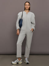 Model is wearing Bomber 1980s Zip Front Jumpsuit in Light Heather Grey, full body styling.