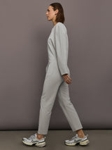 Model is wearing Bomber 1980s Zip Front Jumpsuit in Light Heather Grey, side profile view.