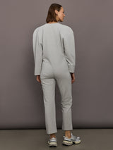 Model is wearing Bomber 1980s Zip Front Jumpsuit in Light Heather Grey, back view.