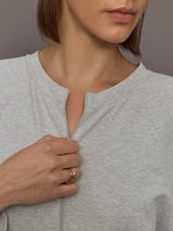 Model is wearing Bomber 1980s Zip Front Jumpsuit in Light Heather Grey, neckline zipper close-up.