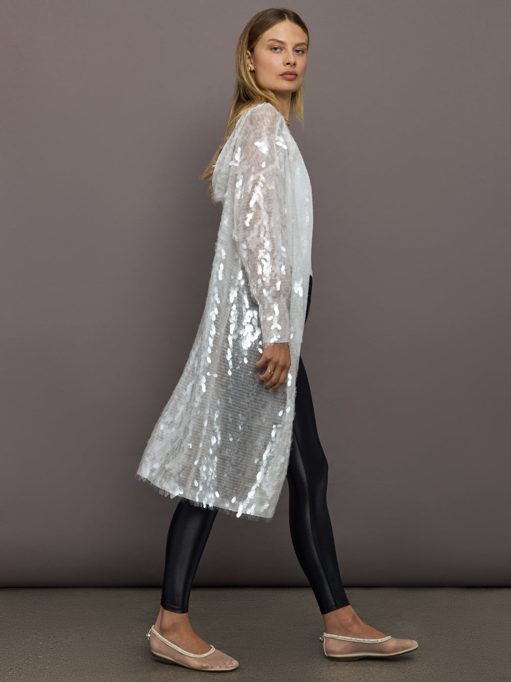 Side view of Hooded Robe to Knee Clear White layered over black leggings.