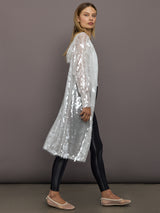 Side view of Hooded Robe to Knee Clear White layered over black leggings.