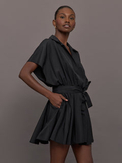 Model wears the Super OS Sleeveless BF NK Shirt Flared Mini Dress in Black with a flared skirt, belted waist and collared neckline.