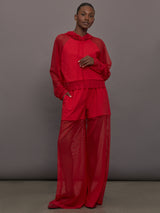 Model wears the Oversized Raglan Sleeve Hooded Cropped Top in Tiger Red, with mesh raglan sleeves and a mesh hood with a breathable design with a relaxed fit.