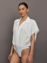 Model wears the Super OS sleeveless boyfriend-neck shirt bodysuit in Snow White, with a relaxed oversized fit and collared neck.