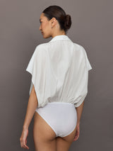 Model wears the Super OS sleeveless boyfriend-neck shirt bodysuit in Snow White, with a relaxed oversized fit and collared neck.