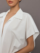 Model wears the Super OS sleeveless boyfriend-neck shirt bodysuit in Snow White, with a relaxed oversized fit and collared neck.