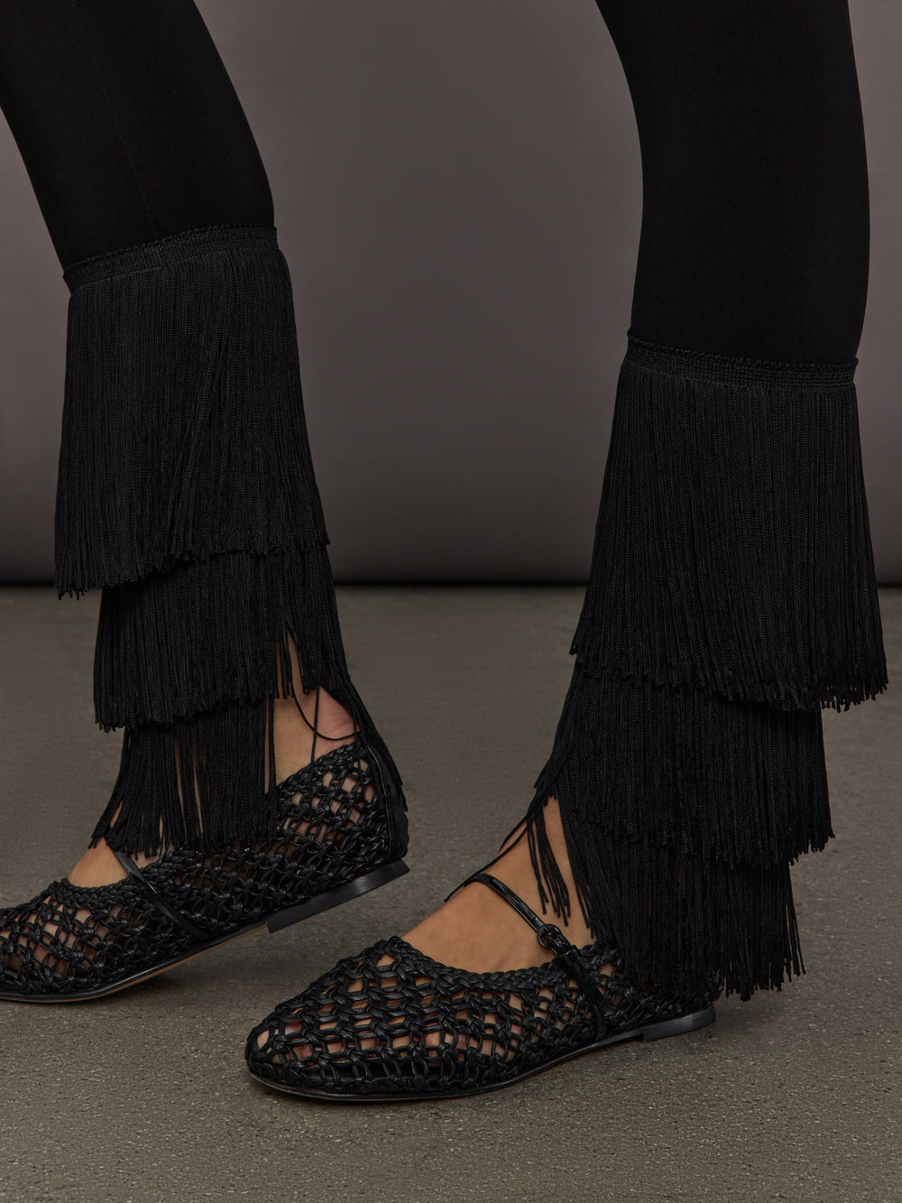 Detailed view of Fringe Hem Cropped Legging Black layered fringe trim at ankle.