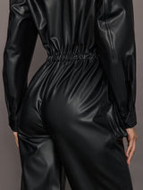 Black shiny jumpsuit on a neutral background