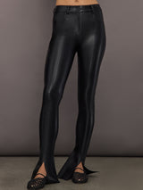 Full front view of model wearing Spat Jeans Black with seam detail and front slit hem.