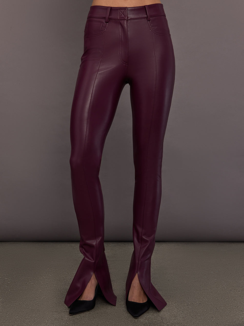 Model is wearing the Spat Jeans in Plum, full body front view.
