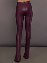 Model is wearing the Spat Jeans in Plum, back view with pocket detail.